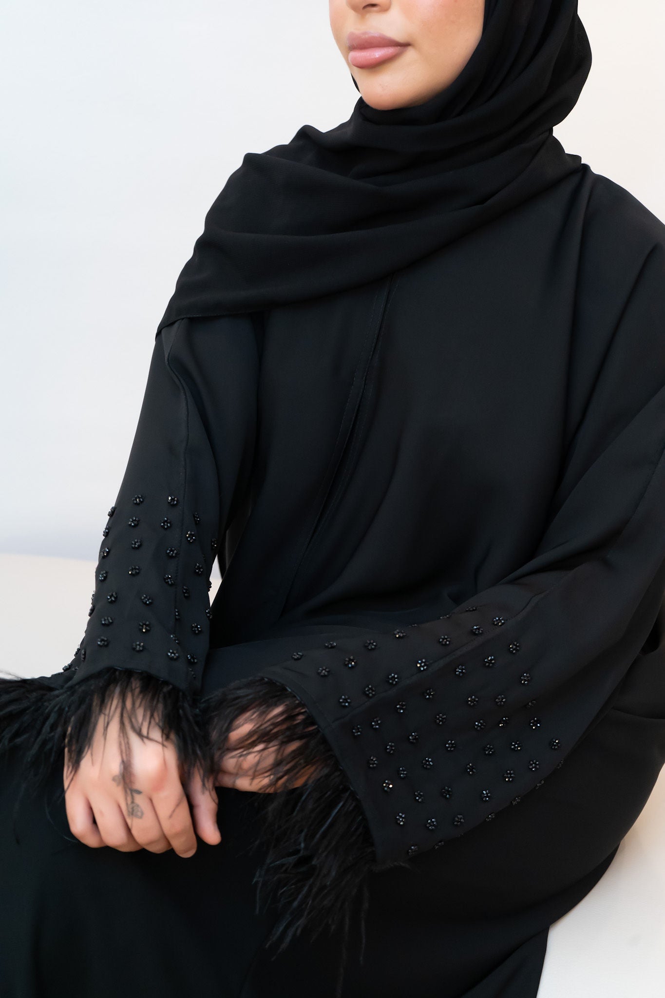 Abaya mit schwarzen Perlen und Federn